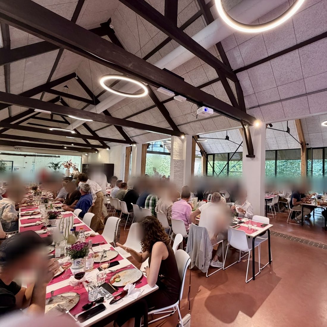 Des convives aux longues tables du Koetshuis&nbsp;; les visages ont &eacute;t&eacute; rendus m&eacute;connaissables